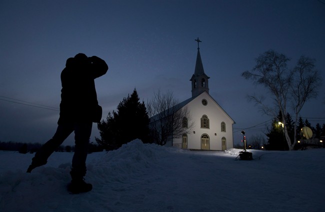 A journalist takes a photo of the church in La Motte, Que., at twilight Wednesday March 13, 2013. Earlier this year, when Quebec Cardinal Marc Ouellet was considered a contender to become pope, the world's attention was briefly trained on his tiny Abitibi hometown of La Motte, where the church has been turned into a community centre and only occasionally hosts mass. THE CANADIAN PRESS/Adrian Wyld