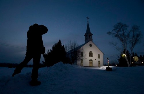 A journalist takes a photo of the church in La Motte, Que., at twilight Wednesday March 13, 2013. Earlier this year, when Quebec Cardinal Marc Ouellet was considered a contender to become pope, the world's attention was briefly trained on his tiny Abitibi hometown of La Motte, where the church has been turned into a community centre and only occasionally hosts mass. THE CANADIAN PRESS/Adrian Wyld