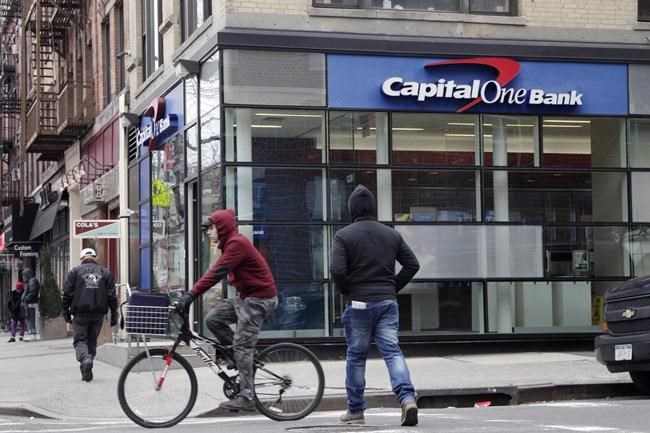 People pass a Capital One Bank in New York on Jan. 21, 2015. A prominent Ontario personal injury law firm has filed a class action on behalf of Canadians affected by the huge Capital One data breach that was disclosed last week. Diamond & Diamond's suit seeks compensation for Canadians who applied for credit cards from Capital One between 2005 and 2019. THE CANADIAN PRESS/AP, Mark Lennihan