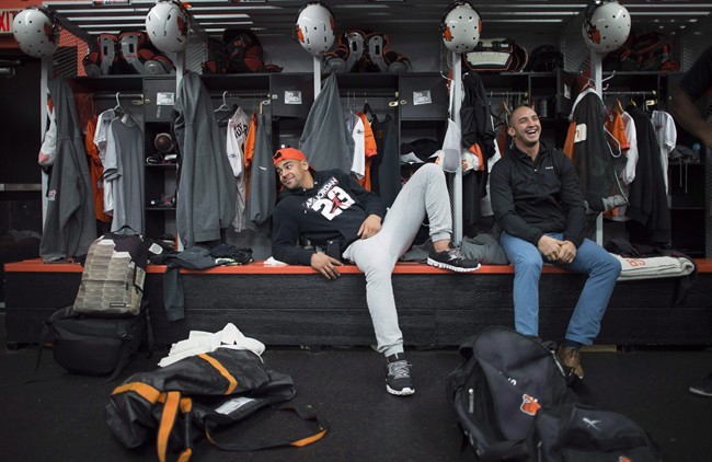 B.C. Lions' running back Andrew Harris, left, jokes around with teammate Marco Lannuzzi at the club's training facility, in Surrey, B.C., on Nov. 16, 2015. A league source said the veteran running back signed a three-year deal Tuesday with the Winnipeg Blue Bombers. THE CANADIAN PRESS/Jonathan Hayward