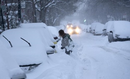 A woman digs her car out of a snowbank during a winter storm in Montreal on Wednesday, February 13, 2019. It's a decision that sparks joy for some, and chaos for others: The snow day. Wintry conditions have forced multiple school closures across the country in recent weeks, with some regions recording an unusually high number of snow days. THE CANADIAN PRESS/Paul Chiasson