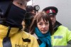 Lucy DeCoutere leaves the Toronto courthouse escorted by police following the reading of the verdict in the Jian Ghomeshi sexual assault trial on Thursday, March 24, 2016. One of three women who accused Jian Ghomeshi of sexual assault outside his workplace says they were never given the option of seeking a peace bond instead of testifying during the radio celebrity's two-week trial earlier this year. THE CANADIAN PRESS/Chris Young