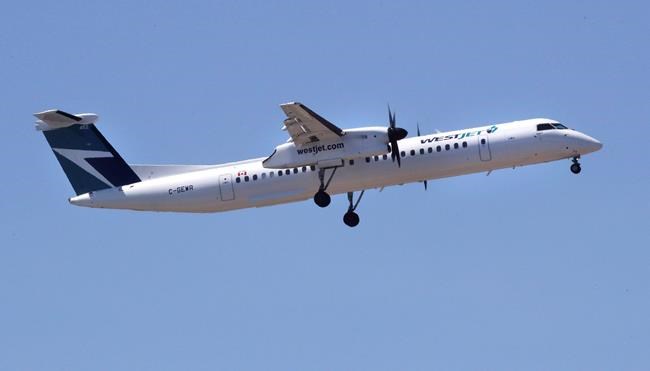 A WestJet airlines passenger plane, a De Havilland DHC-8-400 model, approaches Logan Airport in Boston, Thursday, May 24, 2018. The De Havilland brand will take flight once again, as its parent company announced the re-launch of the Dash 8 aircraft program following its newly minted purchase from Bombardier Inc. THE CANADIAN PRESS/AP, Charles Krupa