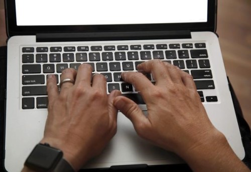 A person works on a laptop in North Andover, Mass., June 19, 2017. The Capital One breach is the latest indication of what experts say is a growing problem, as companies hold more personal data and hackers see more ways to profit off of it. THE CANADIAN PRESS/AP/Elise Amendola