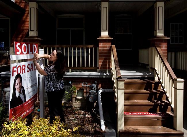 A real estate agent puts up a