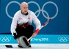Kevin Koe uses his broom to clean the stone during the men's curling match against Switzerland at the 2018 Winter Olympics in Gangneung, South Korea on Feb. 23, 2018. THE CANADIAN PRESS/AP, Aaron Favila