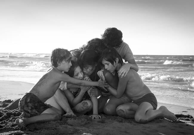 This image released by Netflix shows Yalitza Aparicio, center, in a scene from the film