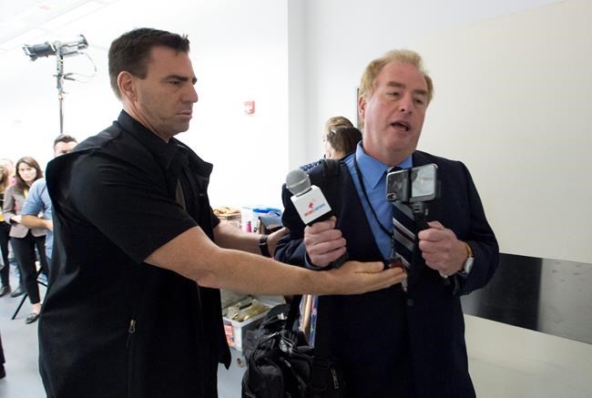 A member of the RCMP removes David Menzies, a reporter from Rebel Media, during a campaign stop for Conservative leader Andrew Scheer at the Abilities Centre in Whitby, Ont. Monday, September 30, 2019. Two right-wing media organizations are turning to the courts after they say their representatives were denied accreditation to cover tonight's election debate. THE CANADIAN PRESS/Jonathan Hayward