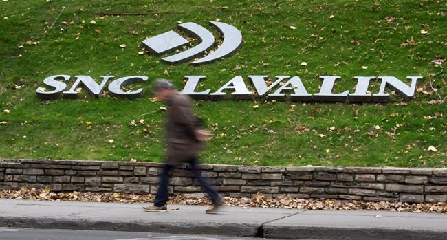 A man walks past the headquarters of SNC Lavalin in Montreal on November 6, 2014. For more than a century, SNC-Lavalin has been viewed with pride in Quebec as it grew from a small firm specializing in hydraulics into a global engineering and construction giant.Founded in 1911, it gained a reputation for building a large dam in Quebec that spearheaded the province's development of hydroelectricity and developing the skillsets for thousands of Quebec workers. THE CANADIAN PRESS/Paul Chiasson