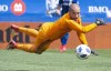 Montreal Impact goalkeeper Evan Bush makes a save off New England Revolution forward Teal Bunbury, not shown, during first half MLS action on May 5, 2018 in Montreal. Bush has been named Major League Soccer's player of the week.THE CANADIAN PRESS/Paul Chiasson