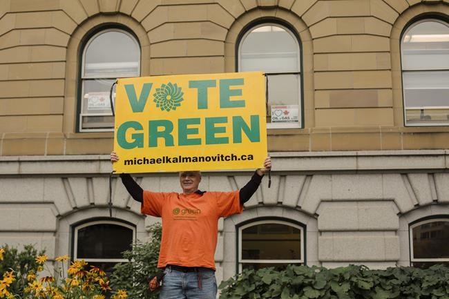 The Green Party candidate in the only riding in Alberta held by the NDP before the federal election call has dropped out of the race and is urging supporters to vote for his New Democrat rival. Green Party candidate Michael Kalmanovitch holds up his sign in front of