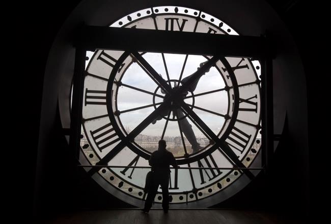 A visitor looks through the clock of the Orsay museum, overlooking Paris, Thursday, Oct. 16, 2014. British Columbia has introduced legislation that would eliminate the need to change the clocks twice a year with the creation of Pacific time. Attorney General David Eby says the Interpretation Amendment Act, if passed, would make daylight saving time permanent. THE CANADIAN PRESS/AP, Michel Euler