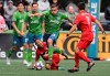 Seattle Sounders forward Jordan Morris (13) leaps over Toronto FC defender Justin Morrow, lower center, as he drives with the ball during the second half of an MLS soccer match, Saturday, April 13, 2019, in Seattle. The Sounders will play Toronto FC in the 2019 MLS Cup in Seattle on Nov.10. THE CANADIAN PRESS/AP/Ted S. Warren
