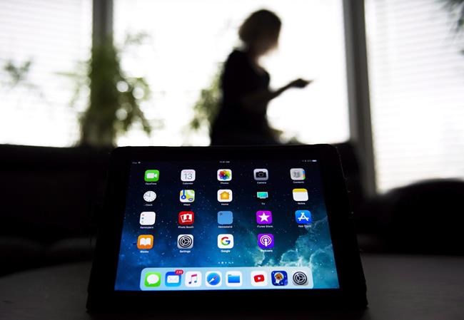 Researchers combing through millions of social-media posts during the federal election campaign say relatively little disinformation has been swirling through cyberspace. A girl uses her smart phone as apps are shown on an iPad in Mississauga, Ont., on November 13, 2017. THE CANADIAN PRESS/Nathan Denette
