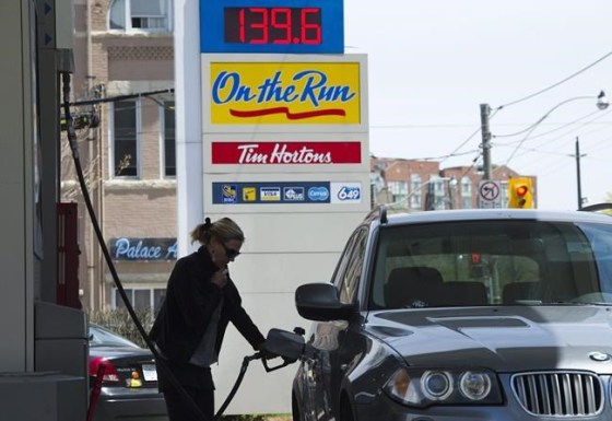 A woman pumps gas in Toronto on Tuesday, May 10, 2011. People in Manitoba, Ontario, Saskatchewan and New Brunswick will be paying more for gasoline and heating fuel Monday when the federal government's carbon tax begins in provinces that refused to impose their own emissions pricing. THE CANADIAN PRESS/Nathan Denette