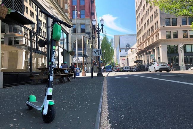 A Lime e-scooter sits parked on a street in downtown Portland, Ore., Thursday, May 9, 2019. A company backed by Toronto Raptors founder John Bitove says it is bringing e-scooter rentals to Calgary and Edmonton in early July. THE CANADIAN PRESS/AP-Gillian Flaccus