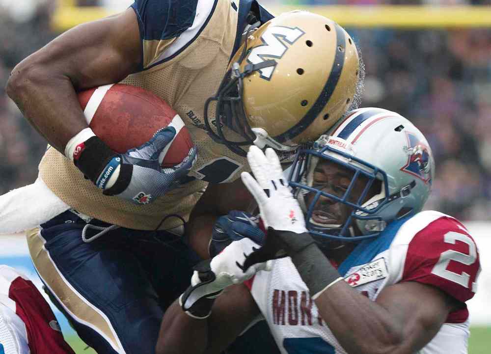 The Canadian Press
Winnipeg Blue Bombers' Cory Watson, left, is tackled by Montreal Alouettes' Mike Edem during first half CFL football action in Montreal Monday.