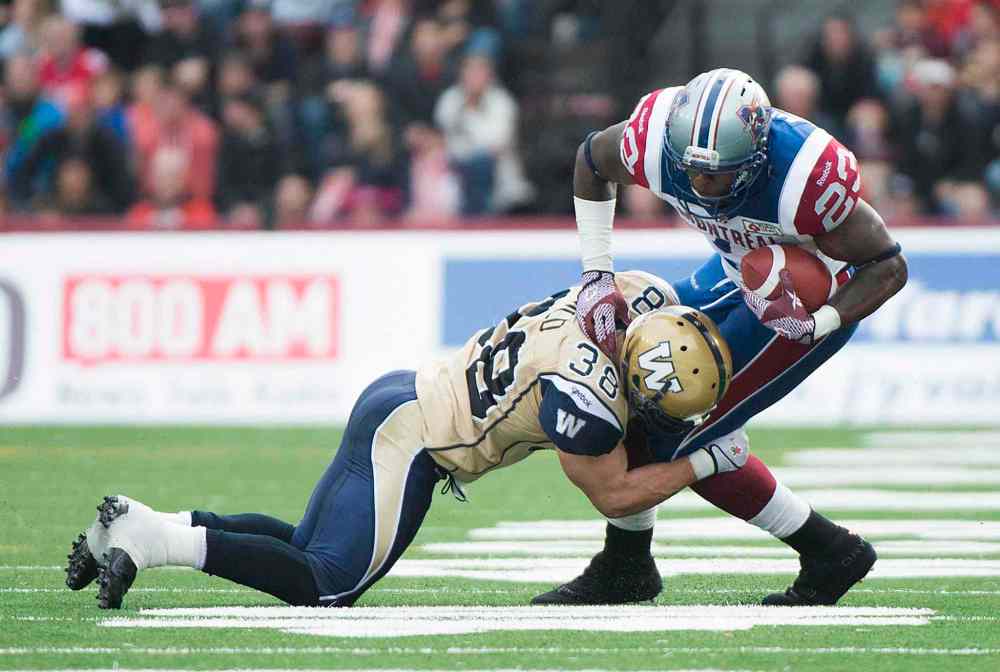 Graham Hughes / The Canadian Press
Winnipeg’s Ian Wild tackles Montreal Alouette Jerome Messam during second-half action in Montreal. The Blue didn’t exactly conquer Everest on Monday, but they showed definite signs of life.