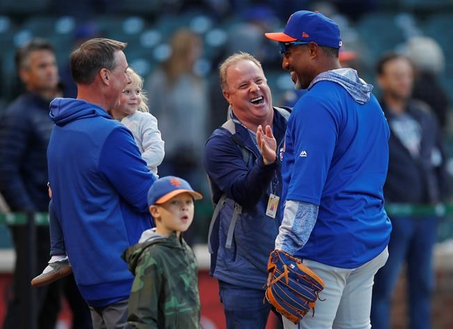 New York Mets bullpen coach Ricky Bones, right, jokes with fans during batting practice for the team's baseball game against the Chicago Cubs on Thursday, June 20, 2019, in Chicago. (AP Photo/Jim Young)