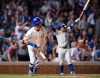 Chicago Cubs' Kyle Schwarber watches his game-ending solo home run while teammate Javier Baez back, celebrates during the 10th inning of a baseball game against the Cincinnati Reds on Tuesday, July 16, 2019, in Chicago. (AP Photo/Paul Beaty)