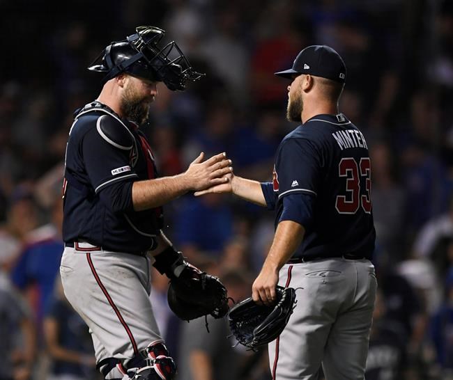 Atlanta Braves closing pitcher A.J. Minter right, celebrates with catcher Brian McCann after the Braves defeated the Chicago Cubs 5-3 in baseball game Wednesday, June 26, 2019, in Chicago. (AP Photo/Paul Beaty)