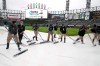 Members of the Chicago White Sox grounds crew remove rainwater off the tarp during a rain delay before the first game of a baseball doubleheader between the White Sox and the Detroit Tigers, Friday, Sept. 27, 2019, in Chicago. (AP Photo/Charles Rex Arbogast)