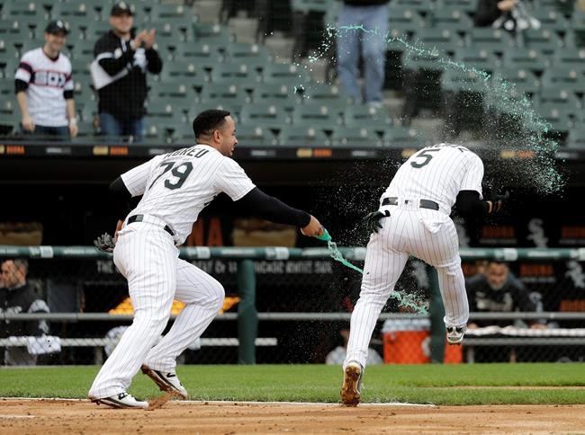Chicago White Sox's Jose Abreu, left, splashes teammate Yolmer Sanchez after Sanchez's RBI-single off Kansas City Royals relief pitcher Kevin McCarthy won the contest in the ninth inning of a baseball game that was suspended due to rain the previous day, in Chicago, Tuesday, May 28, 2019. The White Sox won 2-1. (AP Photo/Charles Rex Arbogast)