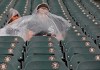 Fans shelter under ponchos during a rain delay of a baseball game between the Chicago White Sox and the Kansas City Royals, Monday, May 27, 2019, in Chicago. (AP Photo/Jim Young)