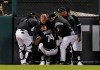 Chicago White Sox manager Rick Renteria, teammates and a team trainer help Eloy Jimenez (74) after he was injured while climbing the wall to go after a home run by Detroit Tigers' Grayson Greiner during the third inning of a baseball game Friday, April 26, 2019, in Chicago. (AP Photo/Nuccio DiNuzzo)