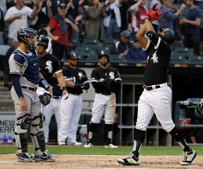 Chicago White Sox's Eloy Jimenez, right, celebrates after hitting a three-run home run as New York Yankees catcher Gary Sanchez, left, looks to the field during the first inning of a baseball game in Chicago, Friday, June 14, 2019. (AP Photo/Nam Y. Huh)