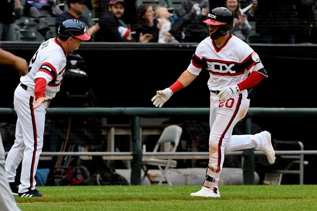 Chicago White Sox's Danny Mendick (20) is congratulated by third base coach Nick Capra, left, after hitting a home run off Los Angeles Angels' Jaime Barria during the fifth inning of a baseball game Sunday, Sept. 8, 2019, in Chicago. (AP Photo/Matt Marton)