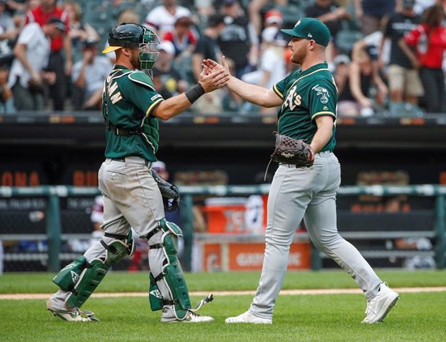Oakland Athletics' Liam Hendriks, right, celebrates with Chris Herrmann, left, after delivering a final out against the Chicago White Sox in a baseball game, Sunday, Aug. 11, 2019, in Chicago. (AP Photo/Kamil Krzaczynski)