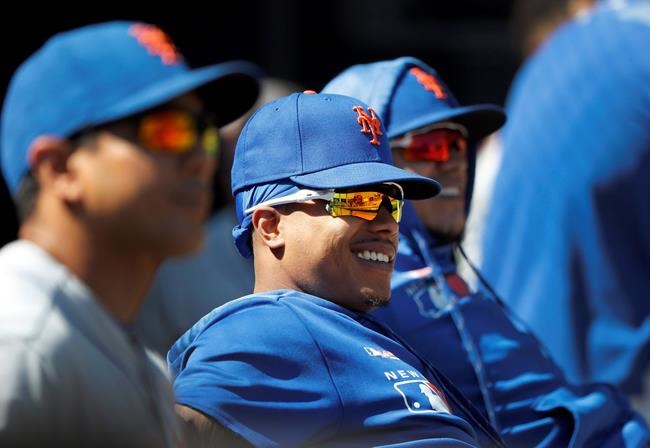 New York Mets' Marcus Stroman, center, smiles in the dugout during the eighth inning of a baseball game against the Chicago White Sox Thursday, Aug. 1, 2019, in Chicago. (AP Photo/Charles Rex Arbogast)