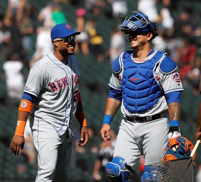 New York Mets' Robinson Cano, left, and Wilson Ramos celebrate the team's 4-0 win over the Chicago White Sox after a baseball game Thursday, Aug. 1, 2019, in Chicago. (AP Photo/Charles Rex Arbogast)