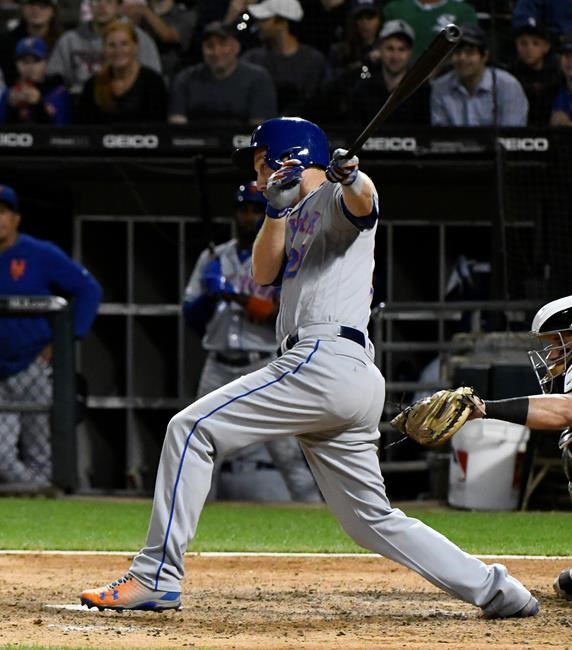 New York Mets' Todd Frazier follows through on an RBI single during the ninth inning of the team's baseball game against the Chicago White Sox on Wednesday, July 31, 2019, in Chicago. (AP Photo/Matt Marton)