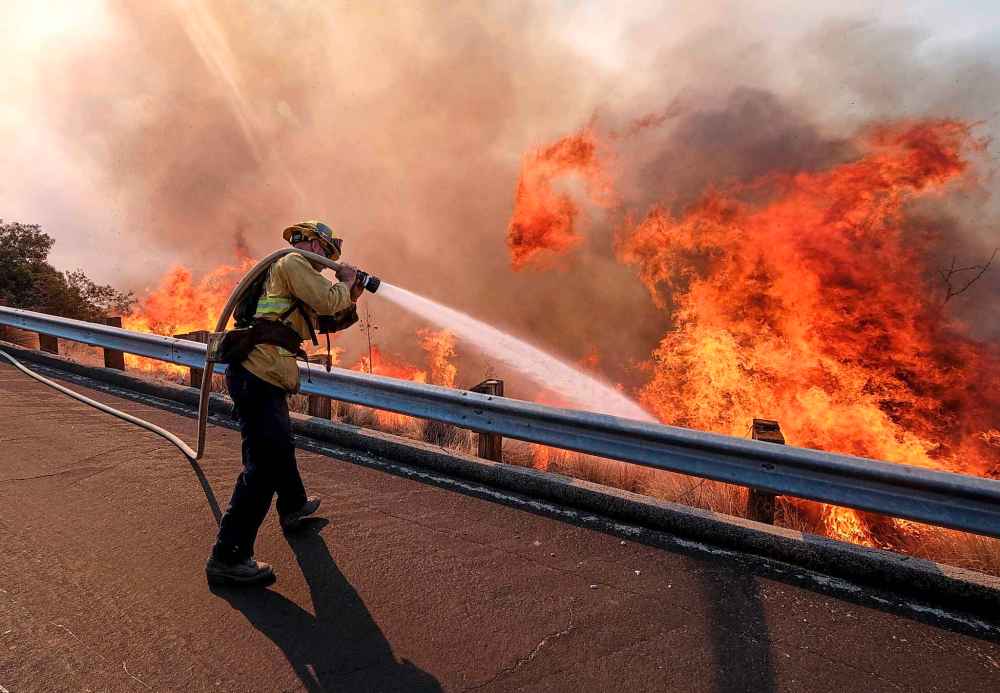 CP
A firefighter battles a fire along the Ronald Reagan (118) Freeway in Simi Valley, Calif., Monday, Nov. 12, 2018. (AP Photo/Ringo H.W. Chiu)