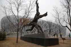 Ng Han Guan / The Associated Press
A tourist poses near giant sculptures near the iconic Bird