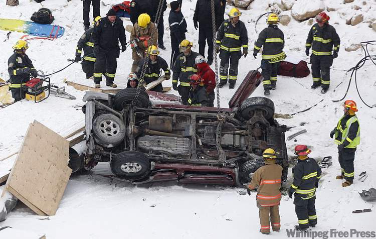 KEN GIGLIOTTI / WINNIPEG FREE PRESS
An SUV crashed through the guard rail on the Disraeli Freeway crashing to the ice below. The vehicle landed upside down, a construction crane that was already on the ice for bridge construction work lifted the SUV so that the injured could be extricated.