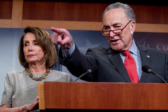 Senate Minority Leader Sen. Chuck Schumer of N.Y., accompanied by Speaker Nancy Pelosi of Calif., left, calls on a reporter during a news conference on Capitol Hill in Washington, Friday, Jan. 25, 2019, after President Donald Trump announces a deal to reopen the government for three weeks. (AP Photo/Andrew Harnik)
