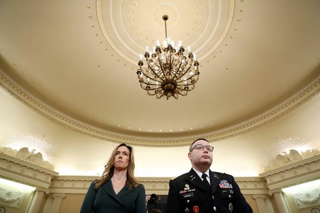 Jennifer Williams, an aide to Vice President Mike Pence, and National Security Council aide Lt. Col. Alexander Vindman stand as they take a break in hearing before the House Intelligence Committee on Capitol Hill in Washington, Tuesday, Nov. 19, 2019. (AP Photo/Andrew Harnik)