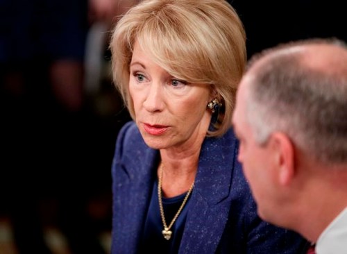 Education Secretary Betsy DeVos, talks with Louisiana Gov. John Bel Edwards before President Donald Trump arrives to speak at the 2019 White House Business Session with Our Nation's Governors in the State Dining Room of the White House in Washington, Monday, Feb. 25, 2019. (AP Photo/Carolyn Kaster)