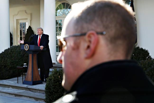 With a Secret Service agent watching in the foreground, President Donald Trump announces a deal to temporarily reopen the government, Friday, Jan. 25, 2019, in the Rose Garden of the White House in Washington. (AP Photo/Jacquelyn Martin)