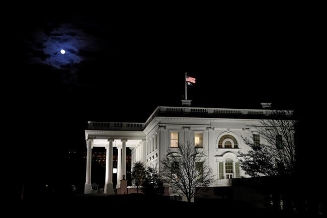 The moon shines through clouds over the White House in Washington, late Tuesday, Nov. 12, 2019. The public impeachment inquiry hearings set to begin Wednesday will pit a Democratic attorney who built his reputation as a federal mob and securities fraud prosecutor against a GOP House Oversight investigator who helped steer some of the most notable probes of the Obama administration. (AP Photo/Patrick Semansky)