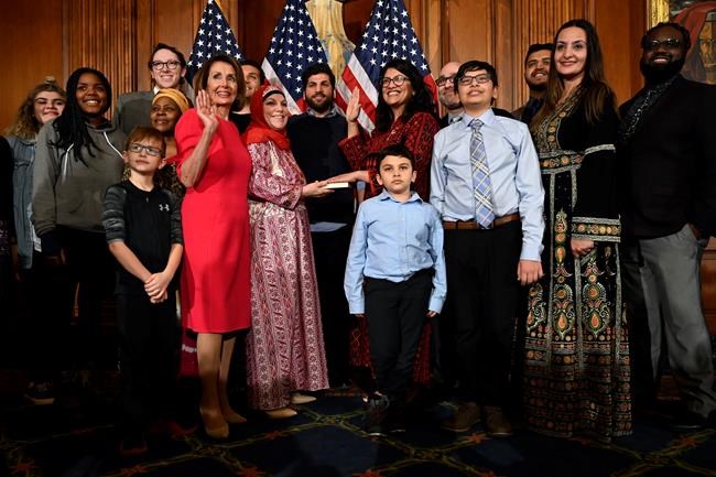 House Speaker Nancy Pelosi of Calif., poses during a ceremonial swearing-in with Rep. Rashida Tlaib, D-Mich., sixth from right, on Capitol Hill in Washington, Thursday, Jan. 3, 2019, during the opening session of the 116th Congress. (AP Photo/Susan Walsh)