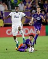 In this Saturday, Aug. 26, 2017, file photo, Vancouver Whitecaps's Alphonso Davies, left, leaps over Orlando City 's Cristian Higuita after the two collided going after the ball during the second half of an MLS soccer match in Orlando, Fla. (AP Photo/John Raoux, file)
