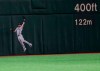 Seattle Mariners center fielder Mitch Haniger jumps to catch a fly ball hit by Oakland Athletics' Stephen Piscotty in the seventh inning of Game 1 of their Major League opening series baseball game at Tokyo Dome in Tokyo, Wednesday, March 20, 2019. (AP Photo/Toru Takahashi)
