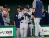 Seattle Mariners right fielder Ichiro Suzuki, center, is hugged by teammates at bench after leaving the field for defense substitution in the fourth inning of Game 1 of the Major League opening baseball series against the Oakland Athletics at Tokyo Dome in Tokyo, Wednesday, March 20, 2019. (AP Photo/Koji Sasahara)