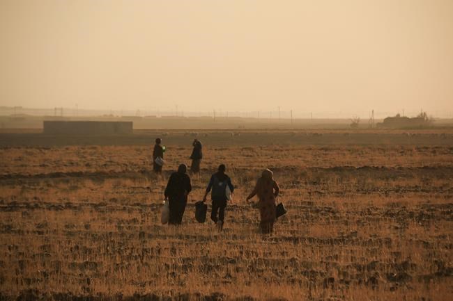 Syrians flee shelling by Turkish forces in Ras al Ayn, northeast Syria, Wednesday, Oct. 9, 2019. Turkish President Recep Tayyip Erdogan announced Wednesday the start of a Turkish military operation against Kurdish fighters in northeastern Syria. (AP Photo/Baderkhan Ahmad)