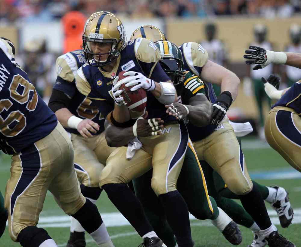 Phil Hossack / Winnipeg Free Press
Winnipeg Blue Bombers' quarterback Drew Willy gets wrapped up in the arms of Edmonton Eskimos Almondo Sewell in the second quarter of Thursday's game at Investors Group Field.