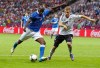 Italy's Mario Balotelli, left, kicks the ball past Germany's Holger Badstuber during the Euro 2012 soccer championship semifinal match between Germany and Italy in Warsaw, Poland, Thursday, June 28, 2012. (AP Photo/Jon Super)